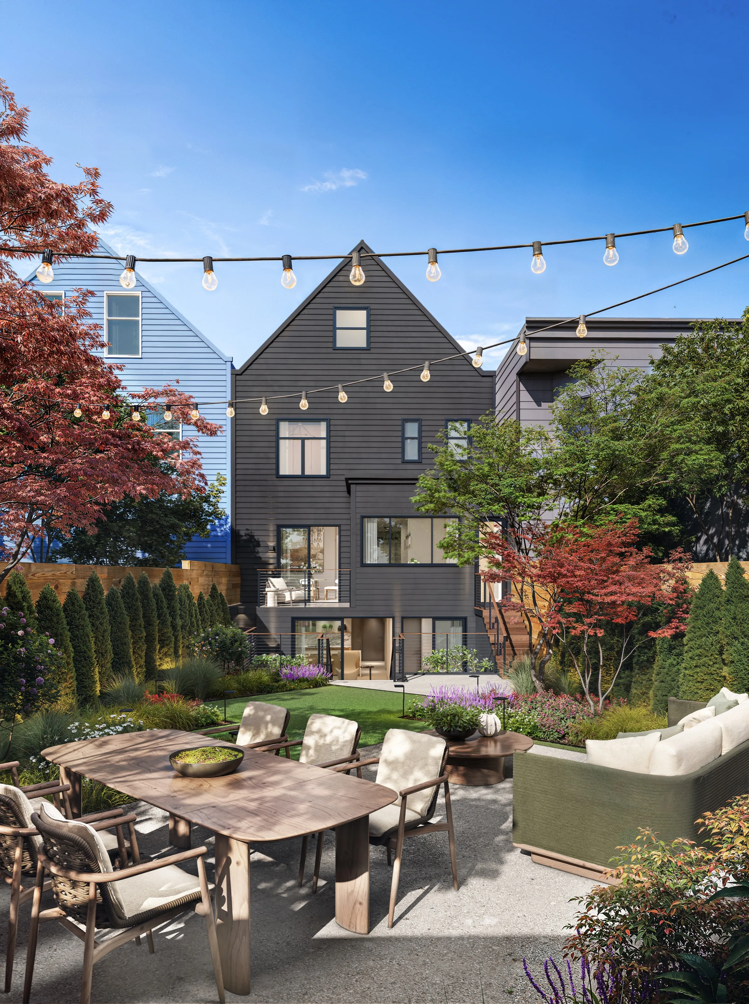 A photorealistic 3D architectural rendering by NoTriangle Studio of the rear of the home at 3740 Sacramento Street in San Francisco, showing the dark charcoal-shingled back facade above a landscaped garden with a dining table, an outdoor sofa, Japanese maples, and string lights.