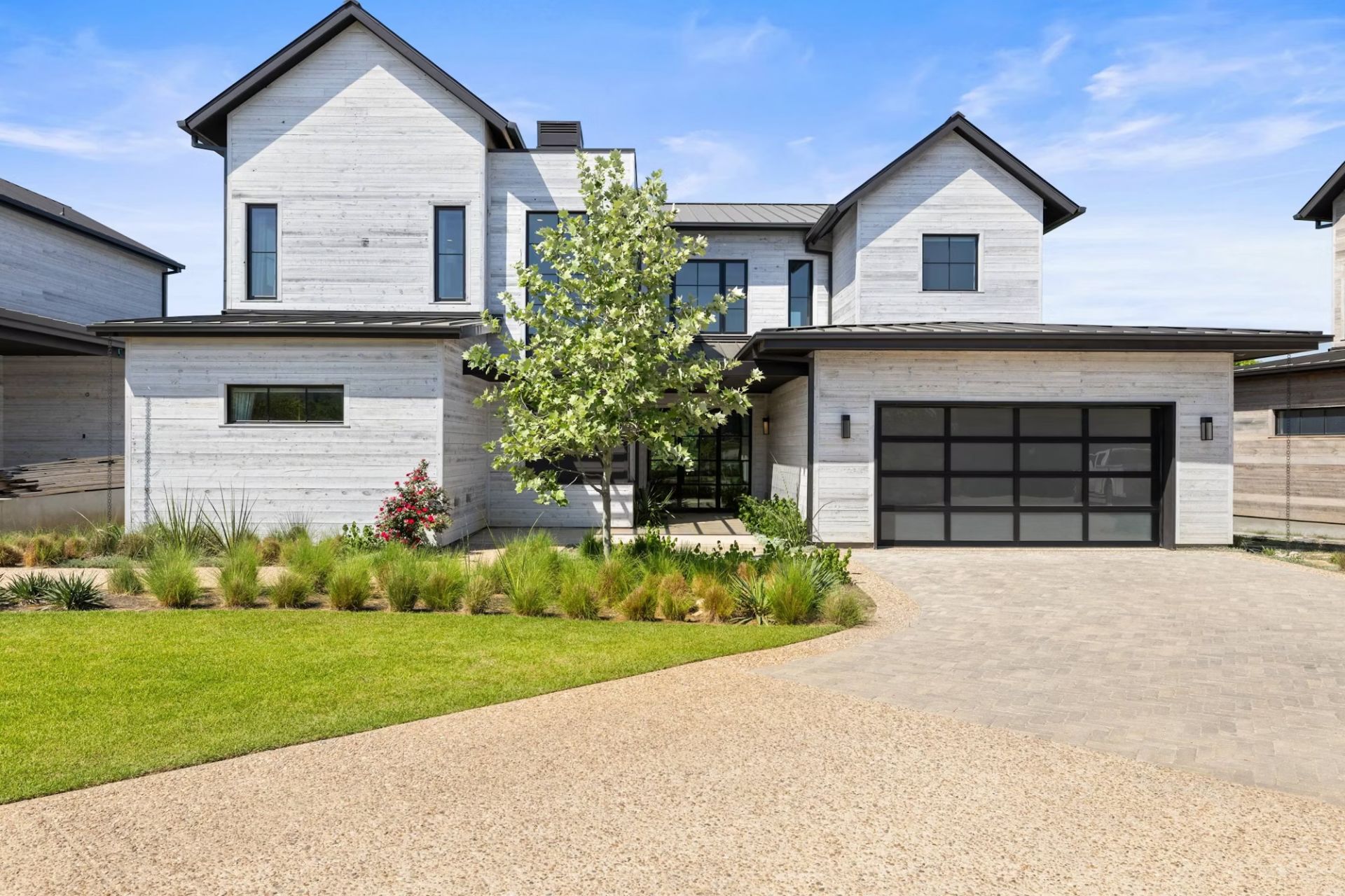 Photorealistic 3D exterior rendering of a whitewashed two-story home at the Driftwood community near Austin, Texas, with landscaped front yard and paved driveway